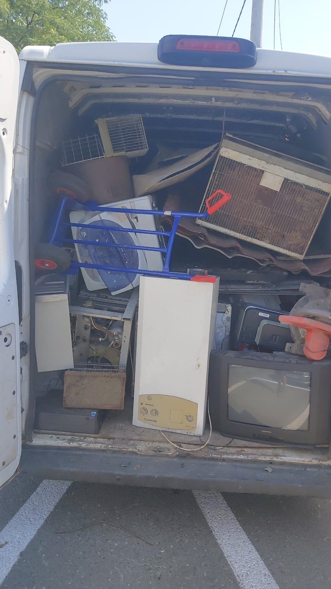 Centrală termică Junkers și televizor vechi încărcate în duba de colectare